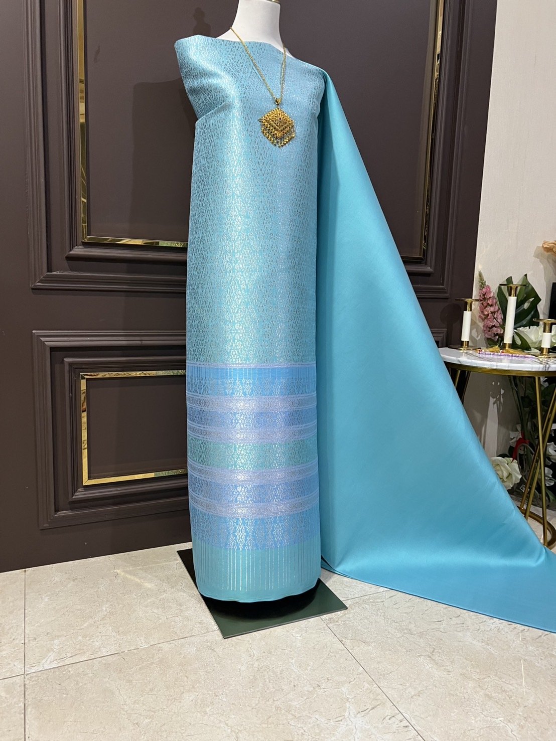 (ผ้าชุด)ผ้าไหมยกดอกลำพูน เกาะเชิงดิ้นเงิน ขนาด 1.02x4.30เมตร ลายอินเดียประยุกต์ พื้นสีฟ้า รหัส N90-29-TR0477