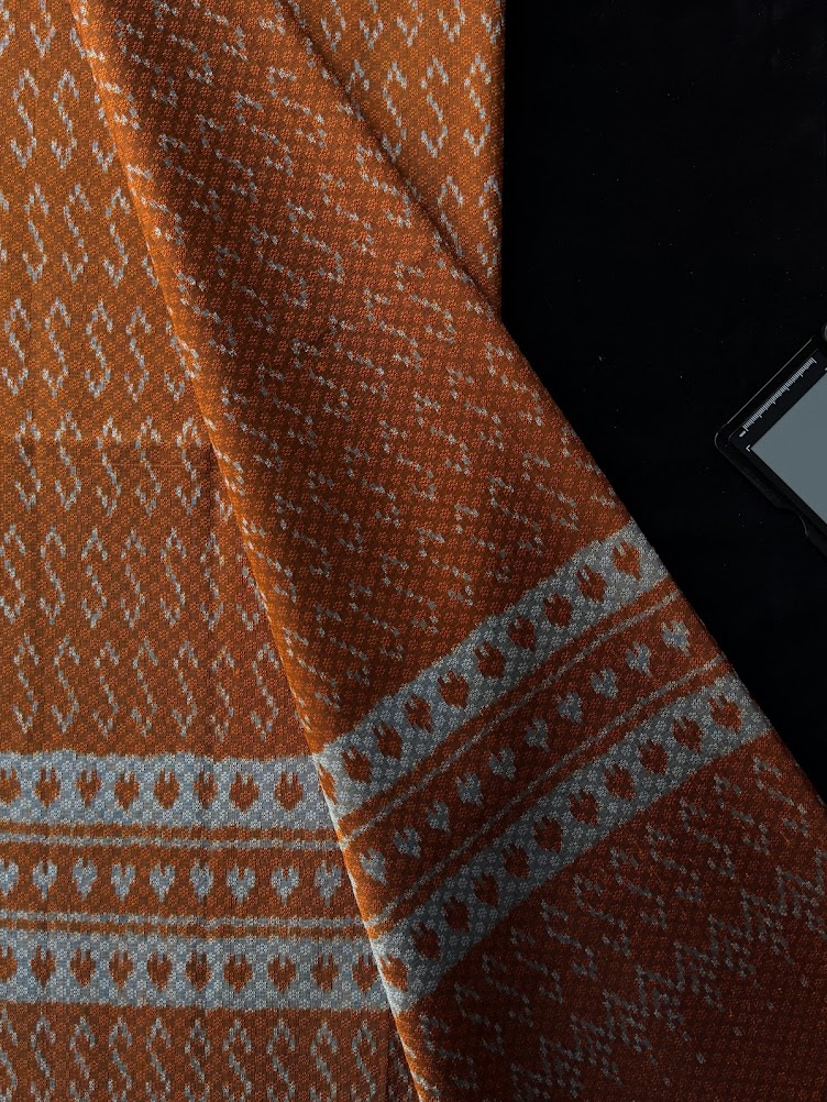 ซิ่น ผ้าไหมมัดหมี่ ทอยกดอก 6ตะกอ ขนาด 1x2 เมตร ลายขอพระราชทาน สีส้มอมเหลือง รหัส PCS-NY-1122686