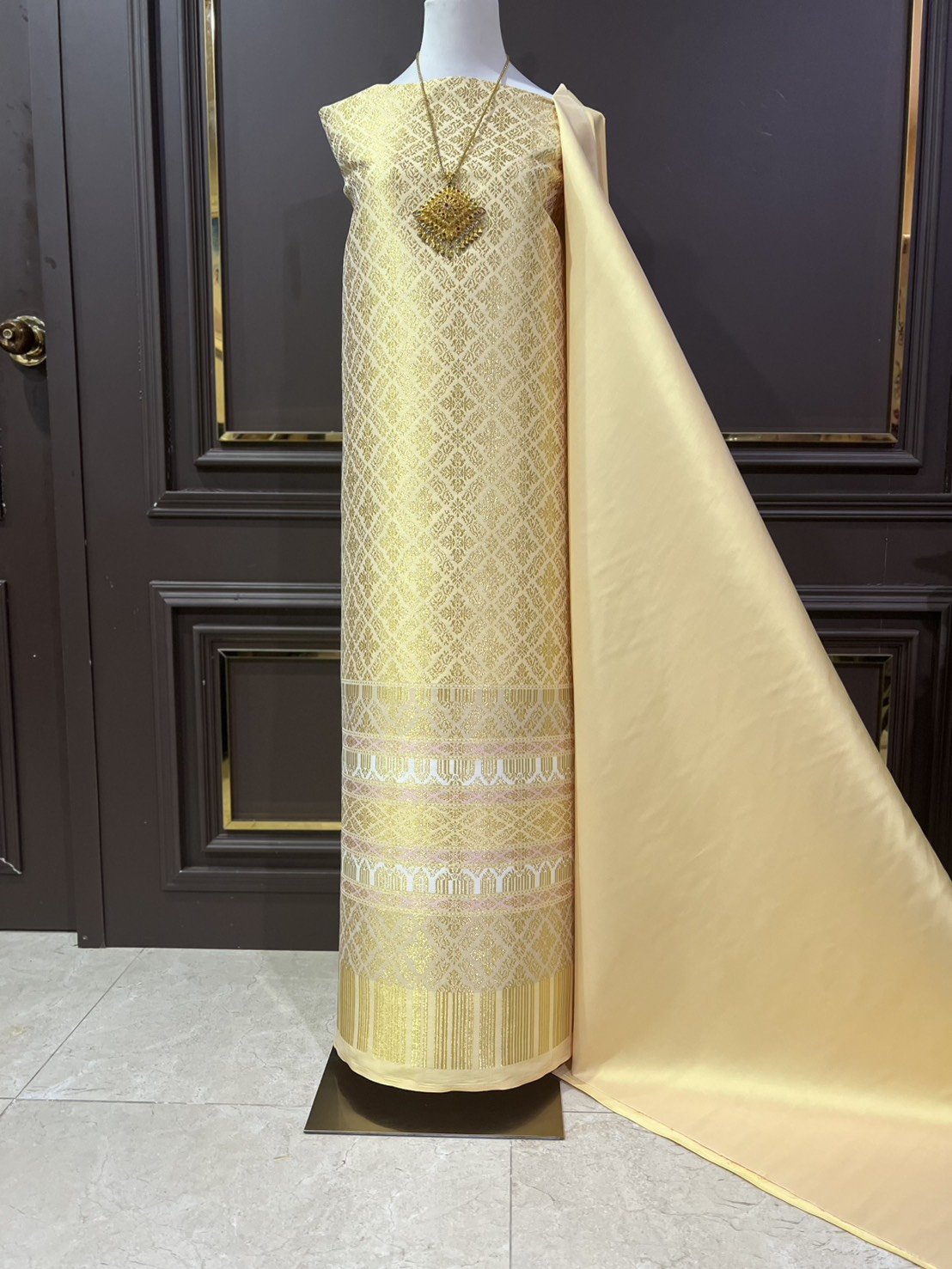 (ผ้าชุด)ผ้าไหมยกดอกลำพูน เกาะเชิงดิ้นทอง ขนาด 1.02x4.53เมตร ลายอมรพรรณ พื้นสีเหลืองเทา รหัส N90-29-TR0551