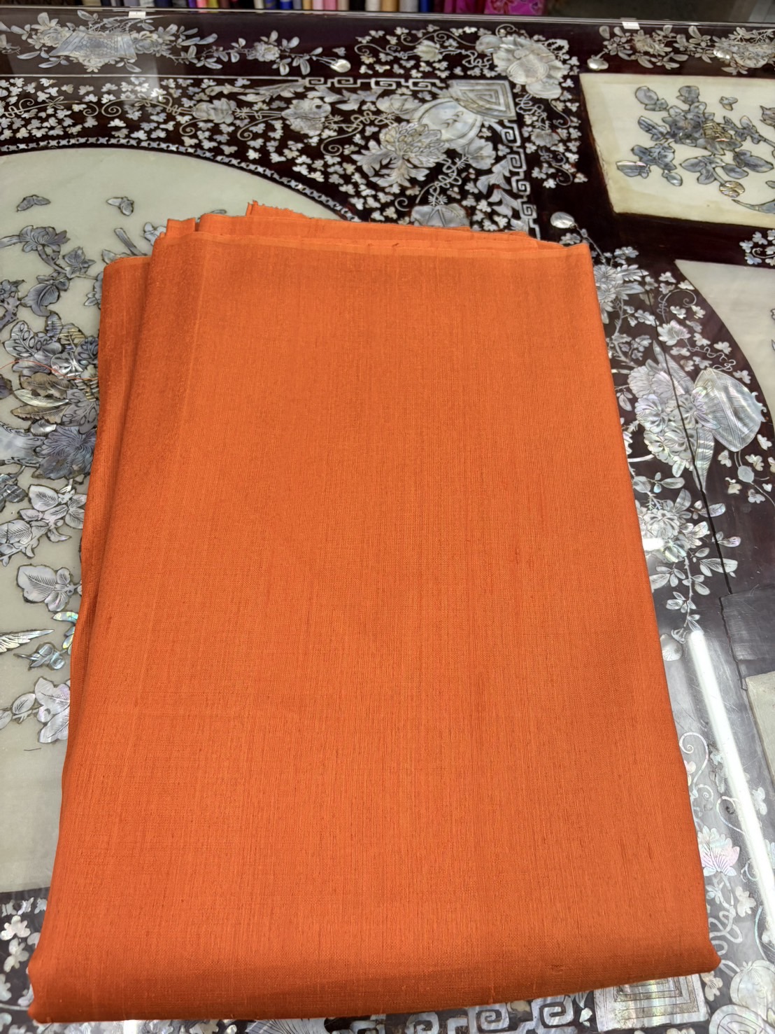 ผ้าไหมสีพื้น ไหมลืบเนื้อเบา ไหมแท้มีขี้ไหม สีส้ม ขายตามความยาวหลา รหัส D-1118671