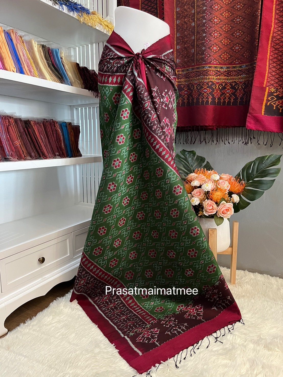 ซิ่น ผ้าไหมมัดหมี่ 5ตะกอ ขนาด 1x2เมตร ลายดอกชบา มีหน้านางชายครุย ท้องผ้าสีเขียวเชิงแดง รหัส L9A-PS-05076833