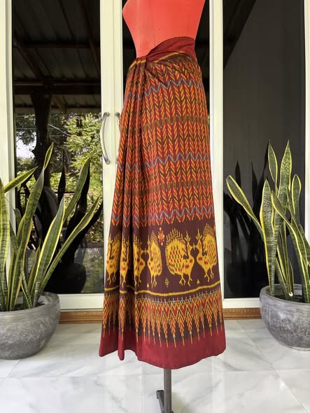 ซิ่น ผ้าไหมมัดหมี่ ทอยกดอกลูกแก้ว ขนาด 1x2เมตร ลายโฮลเชิงนกยูง พื้นสีแดงม่วง รหัส L9A-30-1110682