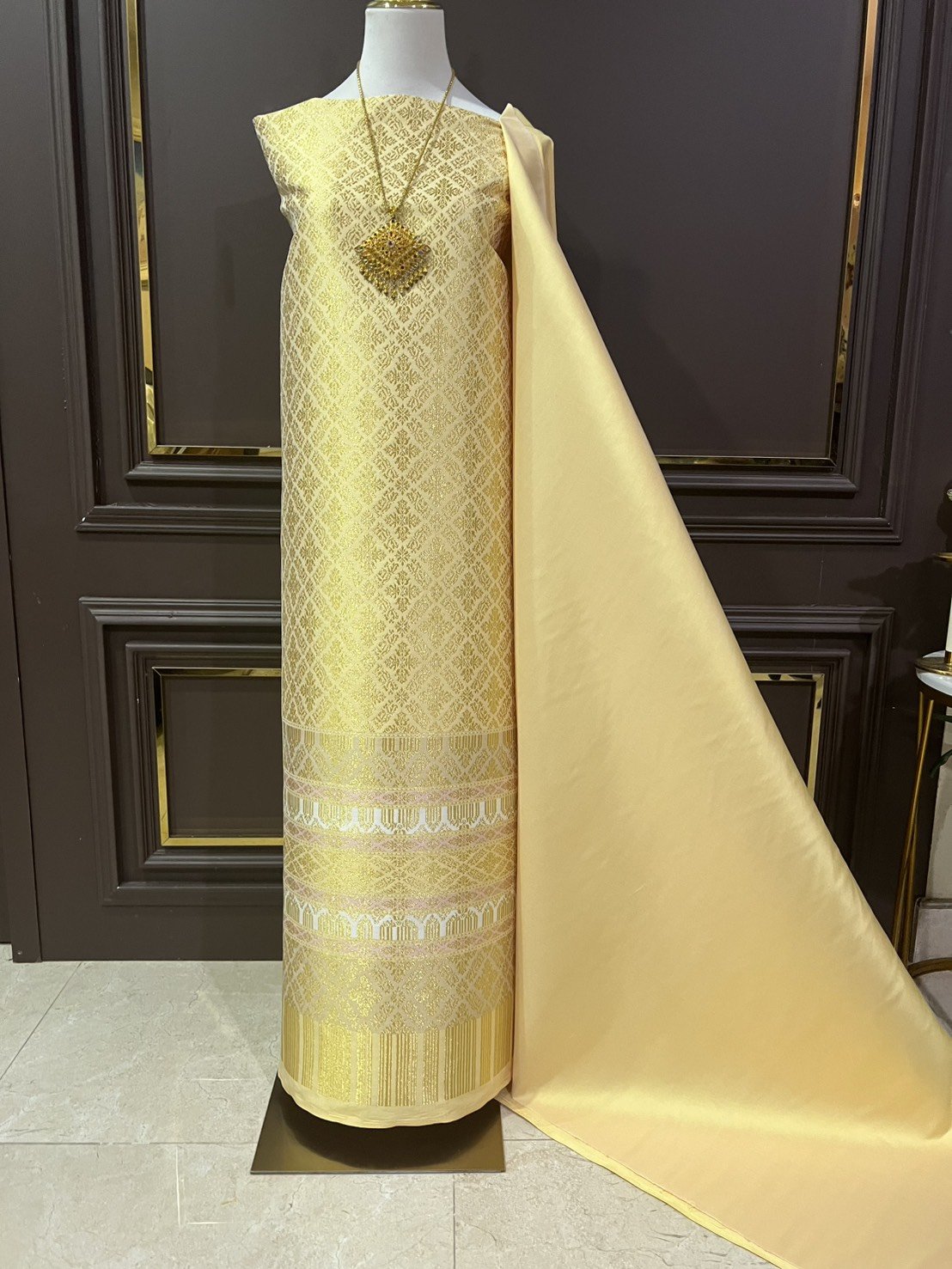 (ผ้าชุด)ผ้าไหมยกดอกลำพูน เกาะเชิงดิ้นทอง ขนาด 1.02x4.53เมตร ลายอมรพรรณ พื้นสีเหลืองเทา รหัส N90-29-TR0551