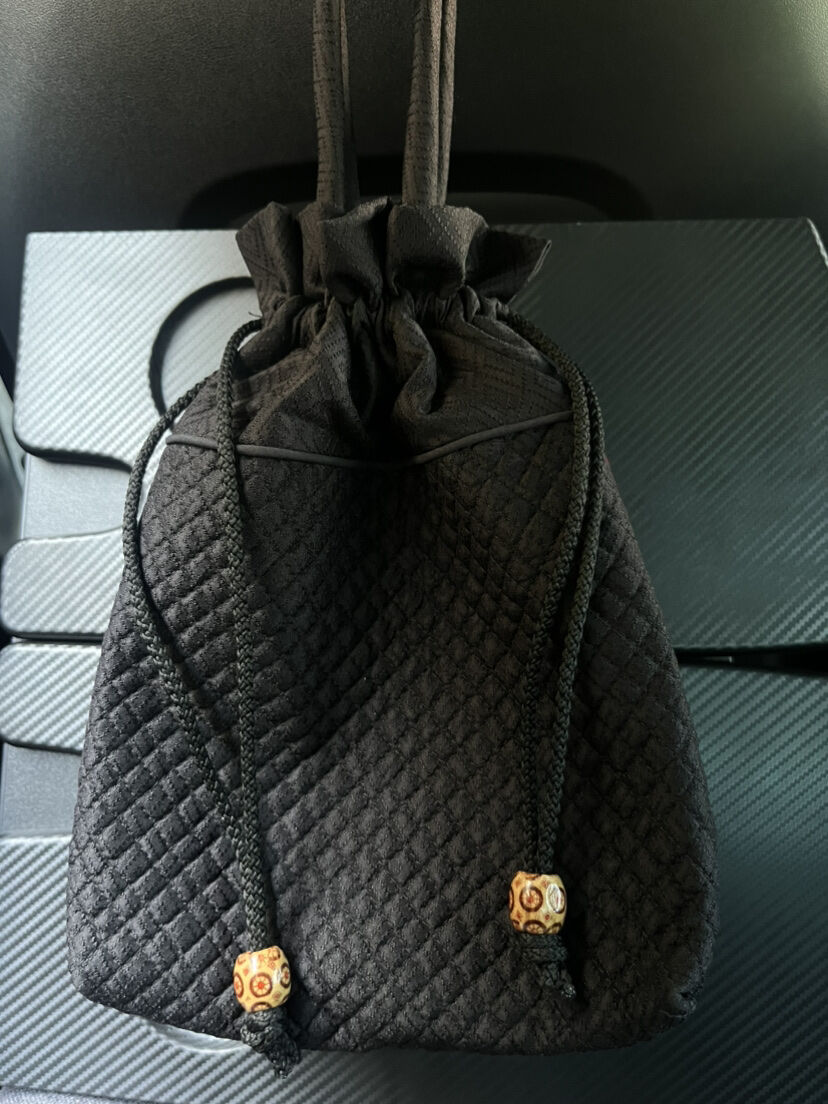 กระเป๋าผ้าไหม มีหูรูด ขนาด 18x20ซม. หูกระเป๋าสูง 13ซม. พื้นสีดำแต่งผ้าไหมขิดสีแดง รหัส GLA-ME-1115681