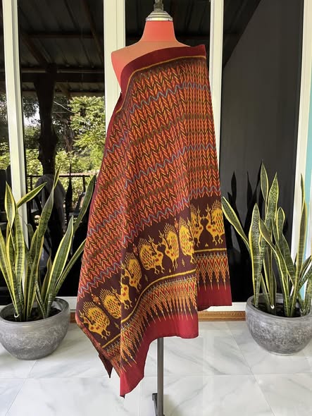 ซิ่น ผ้าไหมมัดหมี่ ทอยกดอกลูกแก้ว ขนาด 1x2เมตร ลายโฮลเชิงนกยูง พื้นสีแดงม่วง รหัส L9A-30-1110682