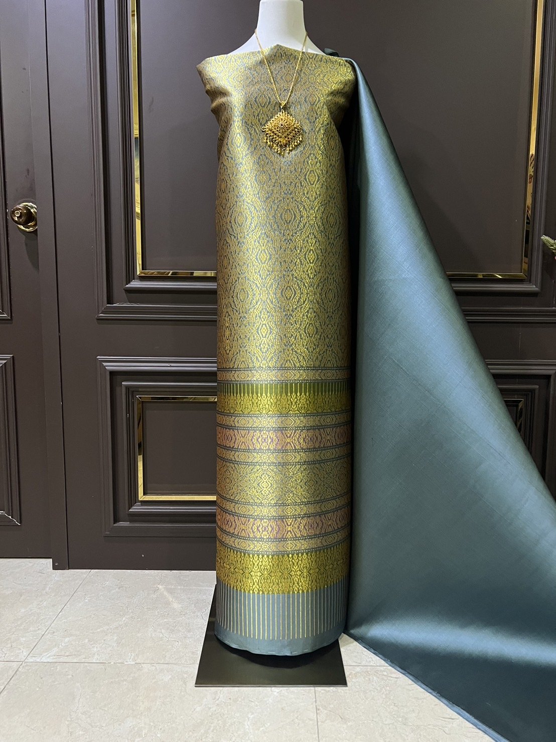 (ผ้าชุด)ผ้าไหมยกดอกลำพูน เกาะเชิงดิ้นทอง ขนาด 1.02x4.46เมตร ลายอินเดีย พื้นสีฟ้าเข้มอมเขียว รหัส N90-29-TR0435