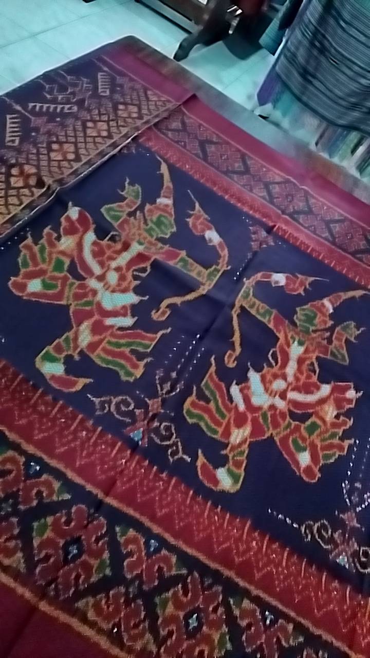 ซิ่น ผ้าไหมมัดหมี่ ทอยกดอก 6ตะกอ ขนาด 1x2.4เมตร ลายรามเกียรติ พระรามแผลงศร มีหน้านางชายครุย พื้นสีแดง รหัส M2A-NY-6SP002