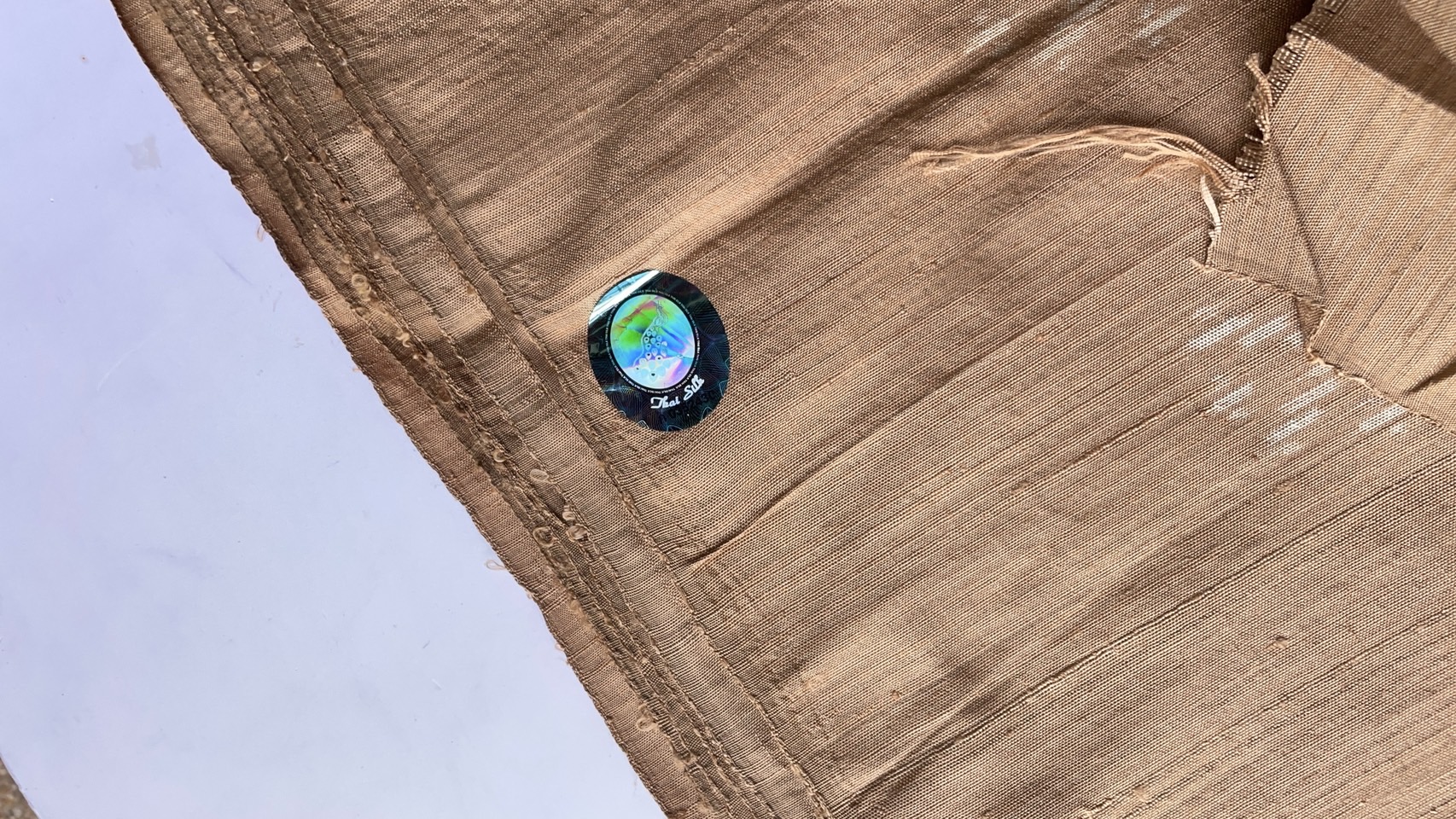 ผ้าไหมมัดหมี่ เนื้อไหมบ้าน ไหมแท้ ตรานกยูง สีธรรมชาติ ลายดอกดาวเรือง สีน้ำตาล (ราคาต่อเมตร) รหัส CISP-NY-SKU-44317