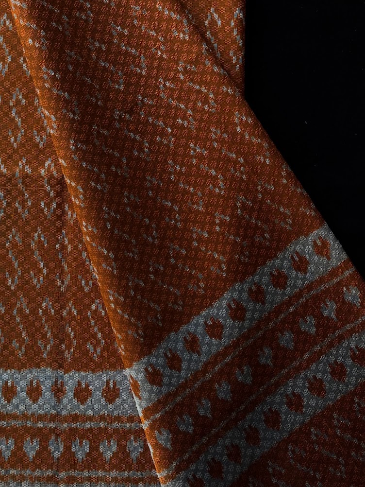 ซิ่น ผ้าไหมมัดหมี่ ทอยกดอก 6ตะกอ ขนาด 1x2 เมตร ลายขอพระราชทาน สีส้มอมเหลือง รหัส PCS-NY-1122686